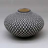 A black on white jar with a raised rim and decorated with an hourglass geometric design
 by Paula Estevan of Acoma