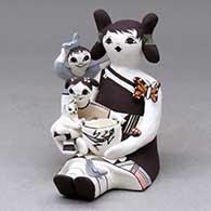 Click for a larger view A sitting grandmother storyteller figure with two children, a butterfly, birds, kitten, pot and lady bug
by Judy Lewis of Acoma