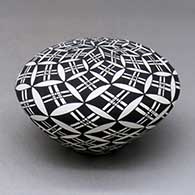 A black on white seed pot decorated with a yucca-leaf snowflake and geometric design
 by Cletus Victorino of Acoma