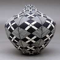 A high-shouldered black on white jar decorated with a stylized checkerboard, fineline and geometric design, click or tap to see a larger version