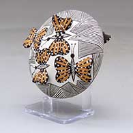 A polychrome seed pot decorated with butterfly wing appliques and a butterfly, fineline and geometric design, click or tap to see a larger version