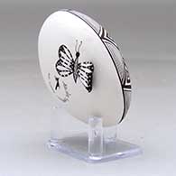 A black on white seed pot decorated with a butterfly wing applique and a butterfly, fineline and geometric design, click or tap to see a larger version