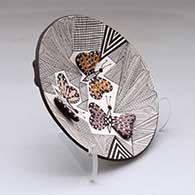 A small polychrome plate decorated with butterfly wing appliques and a butterfly, fineline and geometric design, click or tap to see a larger version