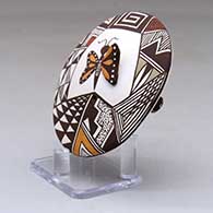 A polychrome seed pot decorated with butterfly wing and lady bug appliques and a butterfly, fineline and geometric design, click or tap to see a larger version