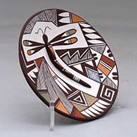 A polychrome plate decorated with dragonfly body and lady bug appliques and a dragonfly, fineline and geometric design, click or tap to see a larger version