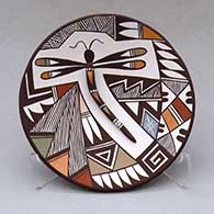 A polychrome plate decorated with dragonfly body and lady bug appliques and a dragonfly, fineline and geometric design
 by Carolyn Concho of Acoma