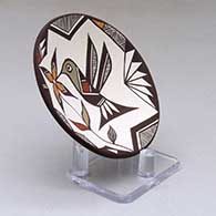 A small polychrome plate decorated with a hummingbird, flower and geometric design, click or tap to see a larger version