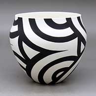 A black on white bowl decorated with a four panel flowing geometric design
 by Eric Lewis of Acoma
