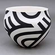 A black on white bowl decorated with a four panel flowing geometric design
 by Eric Lewis of Acoma
