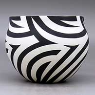 A black on white bowl decorated with a flowing four panel geometric design, click or tap to see a larger version