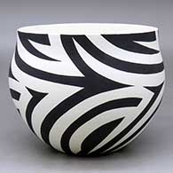 A black on white bowl decorated with a flowing four panel geometric design
 by Eric Lewis of Acoma