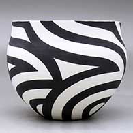 A black on white bowl decorated with a flowing four-panel geometric design, click or tap to see a larger version