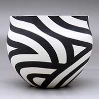 A black on white bowl decorated with a flowing four-panel geometric design, click or tap to see a larger version