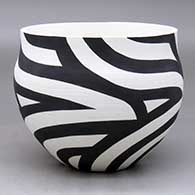 A black on white bowl decorated with a flowing four-panel geometric design
 by Eric Lewis of Acoma