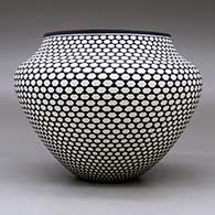 A high-shouldered black on white jar decorated around the body with a geometric design, click or tap to see a larger version