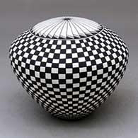 A black on white seed pot decorated with a checkerboard and geometric design
 by Cletus Victorino of Acoma