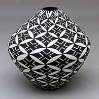 A black on white seed pot decorated with a pumpkin seed snowflake and geometric design
 by Cletus Victorino of Acoma