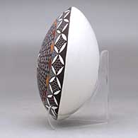 A polychrome seed pot decorated with a fineline, yucca leaf snowflake and geometric design above the shoulder, click or tap to see a larger version