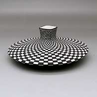 A black on white flat jar with a square neck and opening, decorated with a checkerboard design above and below, click or tap to see a larger version