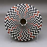 A polychrome flat jar with a short neck and pie crust rim, decorated with a lightning bolt design above and below the shoulder
 by Paula Estevan of Acoma