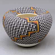 A small polychrome jar with an Infinity rim and decorated with a four panel geometric design built of tiny colored squares
 by Frederica Antonio of Acoma
