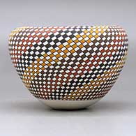 A polychrome jar with an Infinity rim and decorated with a spiral checkerboard geometric design, click or tap to see a larger version
