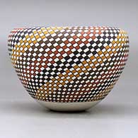 A polychrome jar with an Infinity rim and decorated with a spiral checkerboard geometric design, click or tap to see a larger version