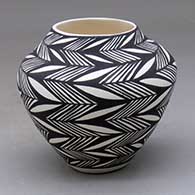 A small black on white jar decorated with a fineline, lightning bolt and geometric design
 by Sandra Victorino of Acoma