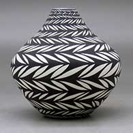 A black on white jar decorated with bands of geometric design, click or tap to see a larger version