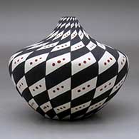 A polychrome tear drop jar decorated with a spiral checkerboard with snow flurries geometric design, click or tap to see a larger version