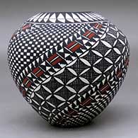 A polychrome jar decorated with a spiral checkerboard, pumpkin seed snowflake, fineline and geometric design, click or tap to see a larger version