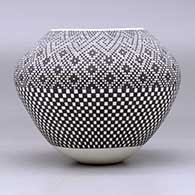 A black on white jar decorated with a checkerboard design below the shoulder and with a tiny square geometric design above the shoulder, click or tap to see a larger version