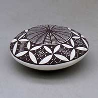 A black on white seed pot decorated above the shoulder with a fineline, yucca leaf snowflake and geometric design, click or tap to see a larger version