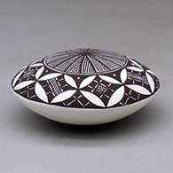 A black on white seed pot decorated above the shoulder with a fineline, yucca leaf snowflake and geometric design, click or tap to see a larger version