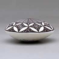 A black on white seed pot decorated above the shoulder with a fineline, yucca leaf snowflake and geometric design, click or tap to see a larger version