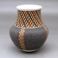 A polychrome jar with a recurved neck and decorated with a four panel tiny square geometric design below the neck and a 3D geometric design around the neck
 by Frederica Antonio of Acoma
