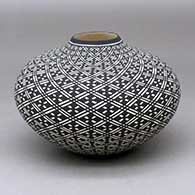 A black on white jar decorated with a spiral geometric design
 by Paula Estevan of Acoma