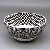 A black on white bowl decorated with a checkerboard design inside and a geometric tiny square design outside
 by Leah Pedro of Acoma