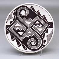 A black on white plate decorated with a Tularosa spiral, fineline and geometric design
 by Franklin Peters of Acoma