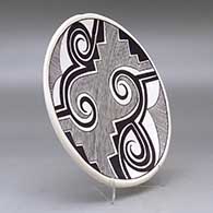 A black on white plate decorated with a fineline, Tularosa spiral , kiva step and geometric design, click or tap to see a larger version
