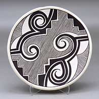 A black on white plate decorated with a fineline, Tularosa spiral , kiva step and geometric design
 by Franklin Peters of Acoma