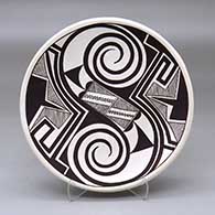 A black on white plate decorated with a Tularosa spiral, fineline and geometric design
 by Franklin Peters of Acoma