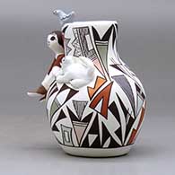A small polychrome jar with a boy and cat perched on the shoulder and a bird on the rim and decorated with a lizard and geometric design, click or tap to see a larger version