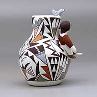 A small polychrome jar with a boy and cat perched on the shoulder and a bird on the rim and decorated with a lizard and geometric design, click or tap to see a larger version