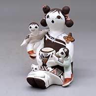 Click for a larger view A sitting grandmother storyteller figure holding two children with a cat, pot, butterfly and lady bug
by Judy Lewis of Acoma