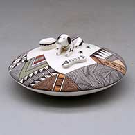 Click for a larger view A polychrome seed pot decorated above the shoulder with dog, dog bone and water bowl appliques and a fineline and geometric design
by George Concho Jr of Acoma