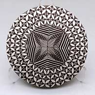 A black on white seed pot decorated above the shoulder with a fineline, pumpkin seed snowflake and geometric design
 by Sharon Lewis of Acoma