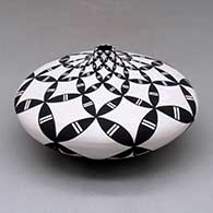 A black on white tear drop jar decorated with a pumpkin seed snowflake and geometric design
 by Dorothy Torivio of Acoma