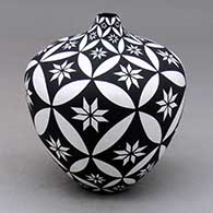 Click for a larger view A black on white tear drop jar decorated with a pumpkin seed snowflake, flower and geometric design
by Dorothy Torivio of Acoma