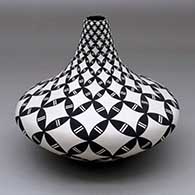A black on white tear drop jar decorated with a pumpkin seed snowflake and geometric design
 by Dorothy Torivio of Acoma